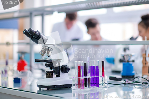 Image of Microscope on the workplace near test tubes