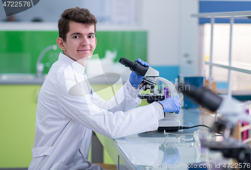 Image of student scientist looking through a microscope