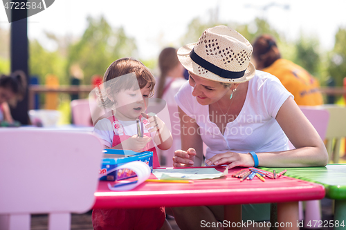 Image of mom and little daughter drawing a colorful pictures