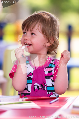 Image of little girl drawing a colorful pictures