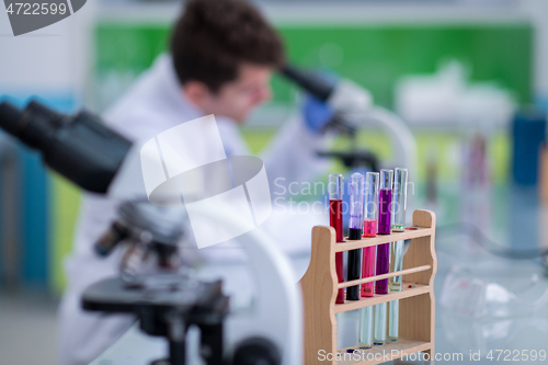 Image of student scientist looking through a microscope