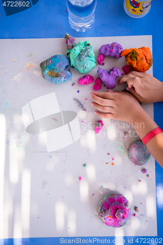 Image of kid hands Playing with Colorful Clay