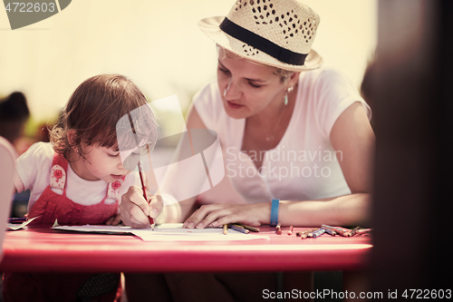 Image of mom and little daughter drawing a colorful pictures