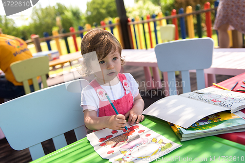 Image of little girl drawing a colorful pictures