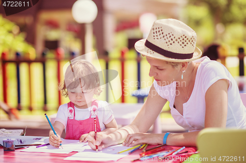 Image of mom and little daughter drawing a colorful pictures