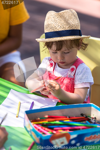 Image of little girl drawing a colorful pictures