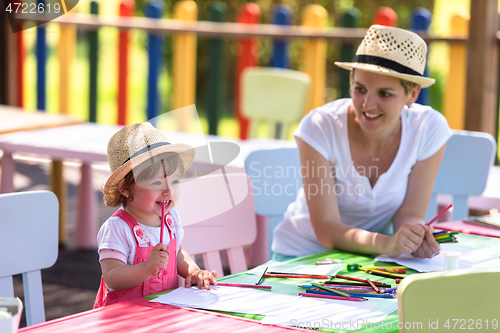 Image of mom and little daughter drawing a colorful pictures