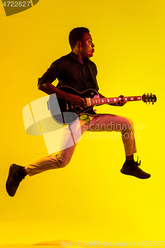 Image of Young african-american jazz musician playing the guitar