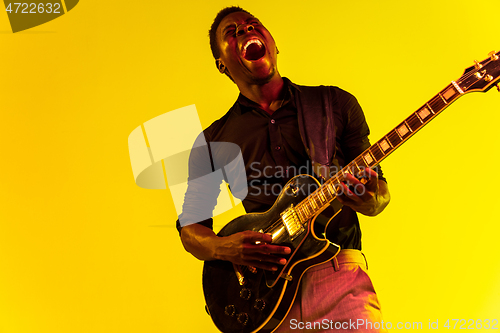 Image of Young african-american jazz musician playing the guitar