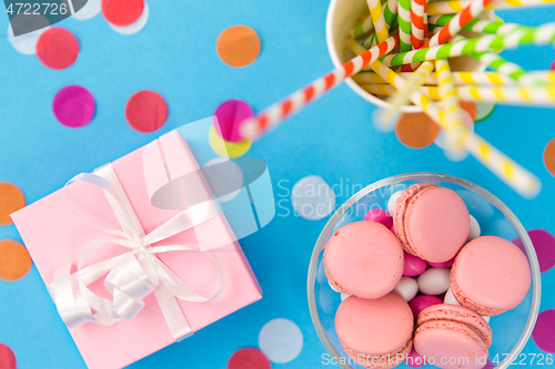 Image of birthday gift, macarons and paper straws for party