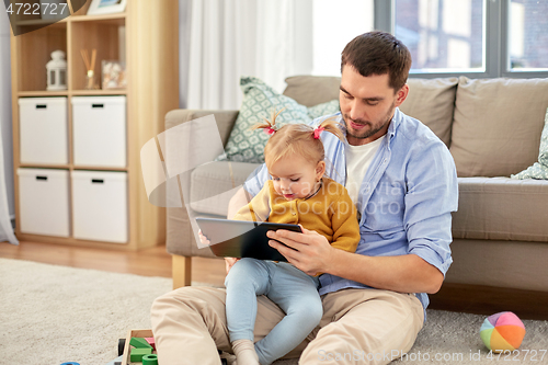 Image of father and baby daughter with tablet pc at home