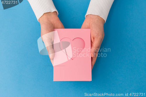 Image of hands holding greeting card with heart