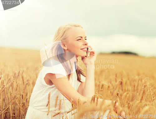 Image of happy young woman calling on smartphone at country