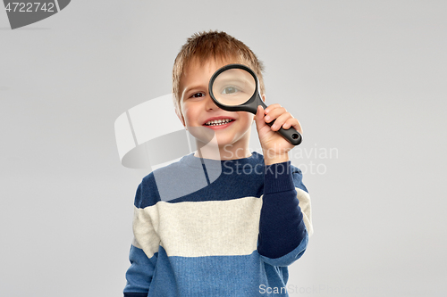 Image of little boy looking through magnifying glass