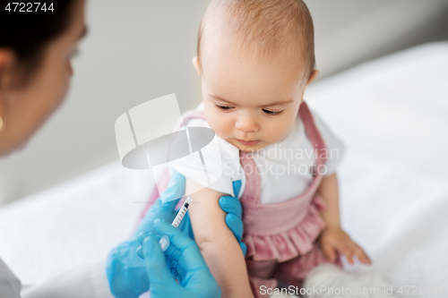 Image of doctor making vaccine for baby patient at clinic