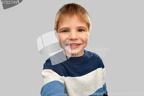 Image of happy little boy in striped pullover taking selfie