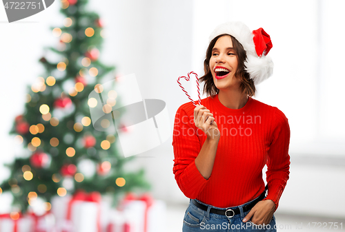 Image of happy young woman in santa hat on christmas