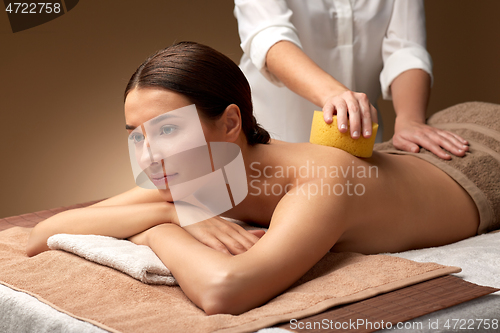 Image of woman having back massage with sponge at spa