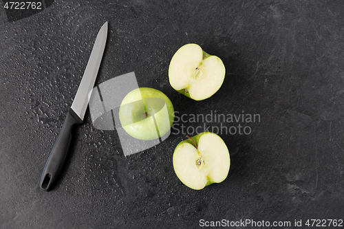 Image of green apples and kitchen knife on slate background