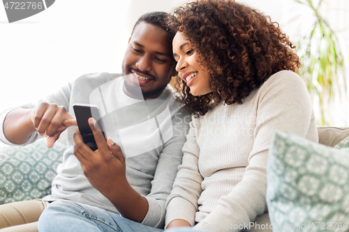 Image of african american couple with smartphone at home