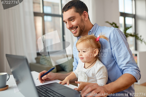 Image of working father with baby daughter at home office