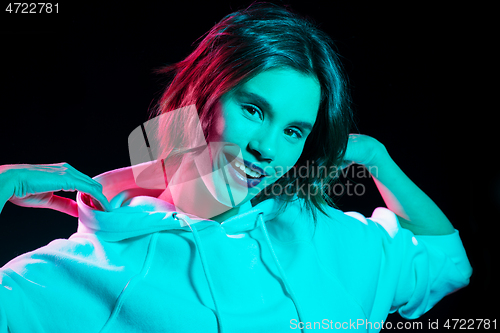 Image of woman wearing hoodie in neon lights over black