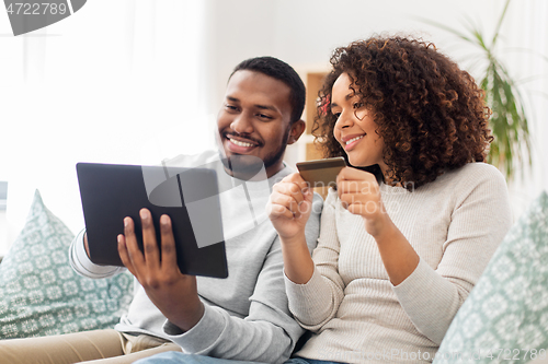 Image of couple with tablet pc and credit card at home