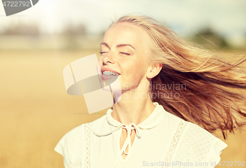 Image of smiling young woman in white on cereal field