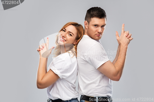 Image of couple in white t-shirts shirts making gun gesture