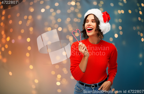 Image of happy young woman in santa hat on christmas