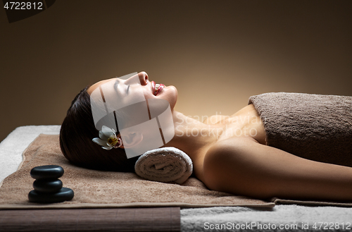 Image of young woman lying at spa or massage parlor