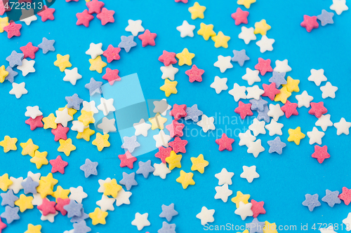 Image of star shaped pastry sprinkles on blue background