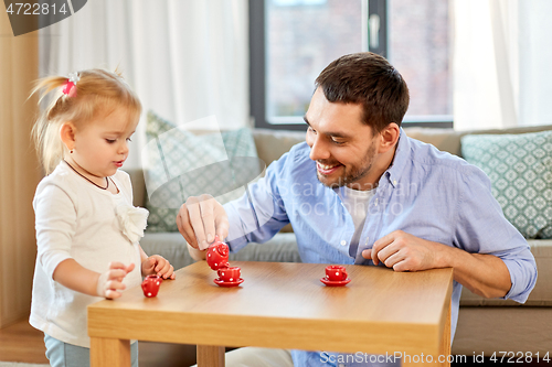 Image of father and daughter playing tea party at home