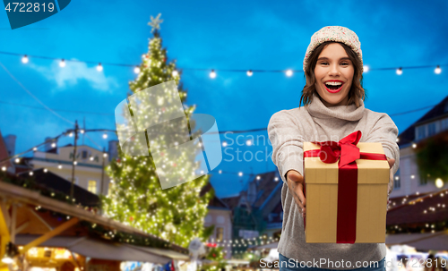 Image of happy woman holding gift box at christmas market