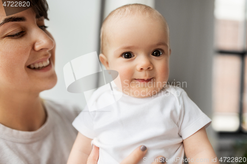 Image of happy young mother holding little baby daughter