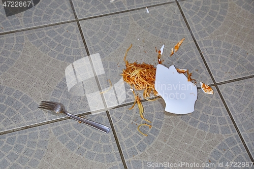 Image of Fallen plate of pasta in the kitchen floor