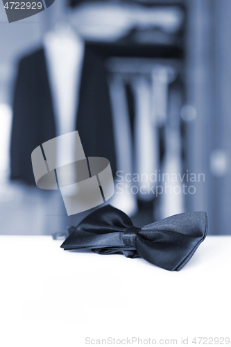 Image of Bow tie. Open closet and tuxedo.