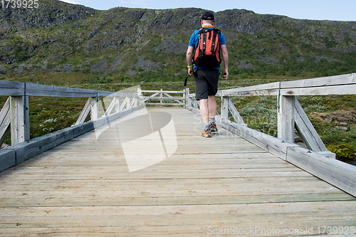 Image of Man walking over bridge