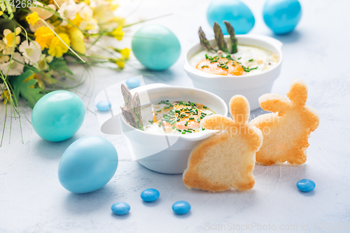 Image of Shirred eggs (Oeuf cocotte) or baked eggs with green asparagus with Easter bunny and eggs