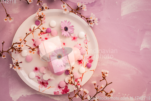 Image of Pink Easter eggs with blooming branch and sweets for Easter and spring