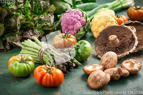 Image of Assortment of organic vegetables and edible mushrooms on green background