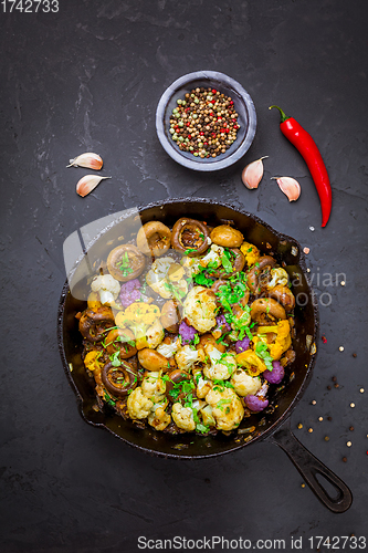 Image of Roasted mushrooms and cauliflower, with onion and herbs in pan