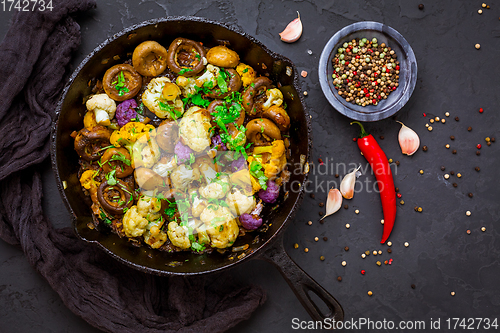 Image of Roasted mushrooms and cauliflower, with onion and herbs in pan