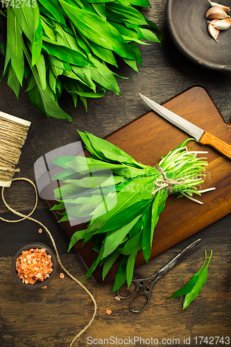 Image of Bunch of Ramson or bear leek (Allium ursinum) with pink Himalayan salt on cutting board