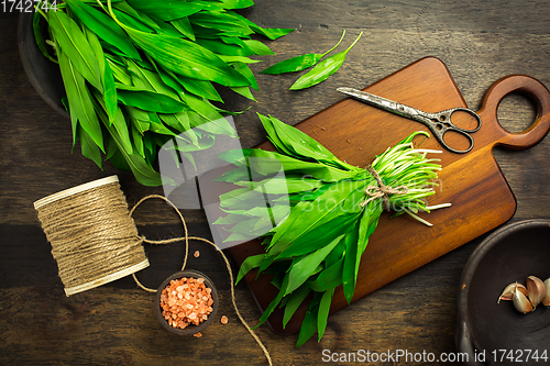 Image of Bunch of Ramson or bear leek (Allium ursinum) with pink Himalayan salt on cutting board