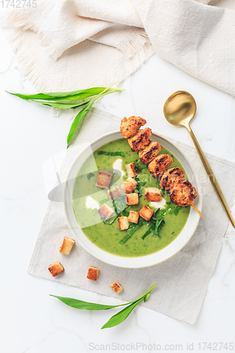 Image of Ramson or bear leek soup with crouton, sour cream and turkey skewer