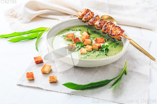 Image of Ramson or bear leek soup with crouton, sour cream and turkey skewer