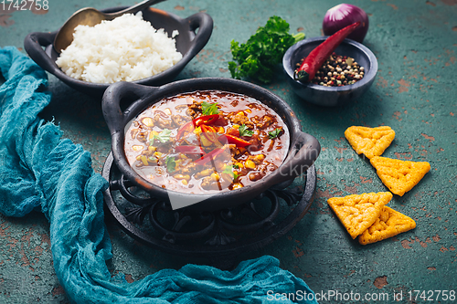 Image of Hot Mexican Chili con carne with rice and tortilla chips and spices