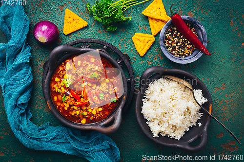 Image of Hot Mexican Chili con carne with rice and tortilla chips and spices