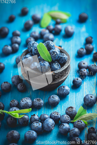 Image of Organic blueberries on blue wooden background